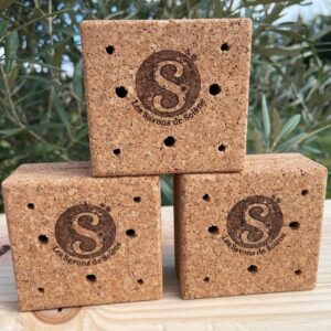 3 boites en lièges fermées superposées sur la tranche, devant un olivier