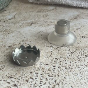 Les 2 parties d'un porte savon aimanté posées sur une pierre de travertin