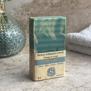 Savon debout entouré de son étiquette kraft sur le bas, sur une pierre de travertin