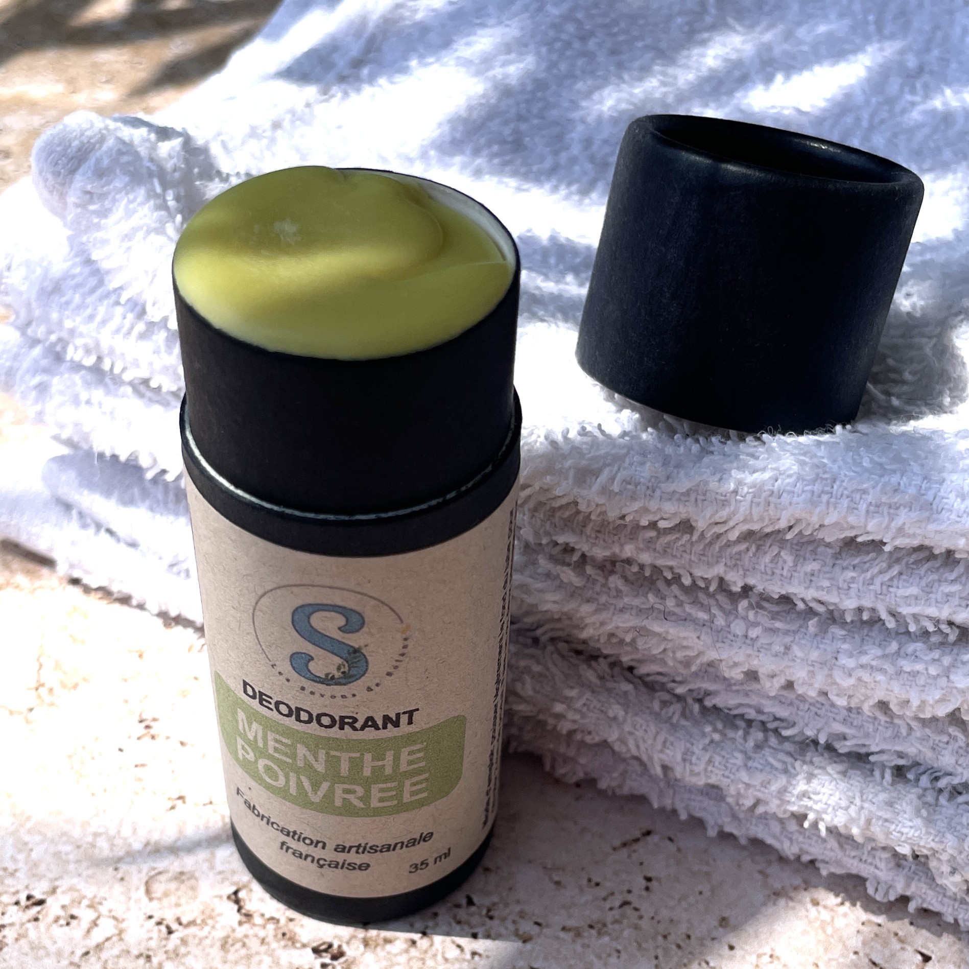 Tube noir ouvert laissant appercevoir le déodorant jaune ( étiquette verte)