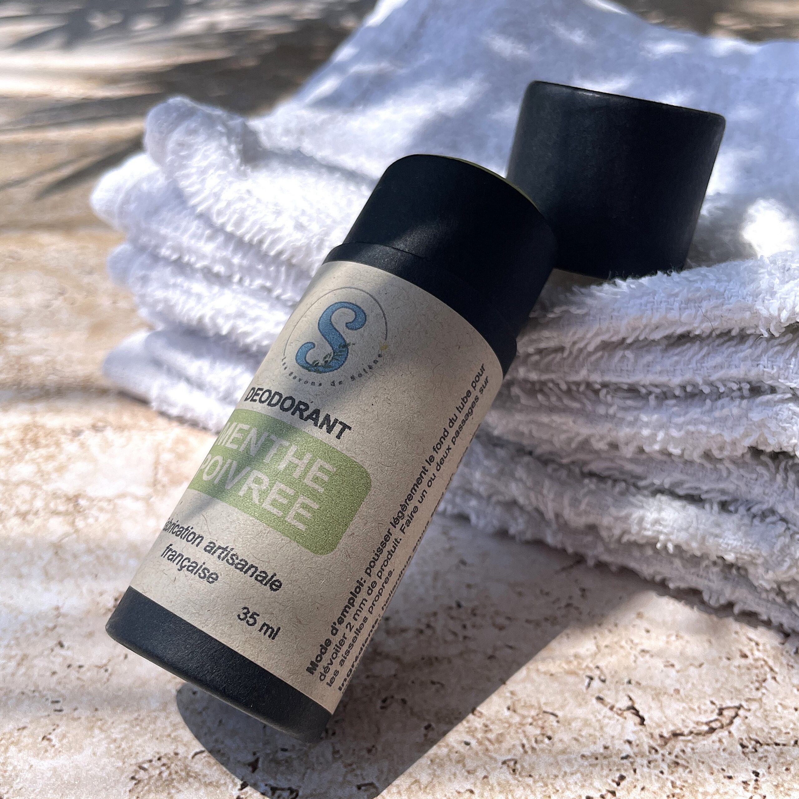 Tube noir couché sur une serviette blanche (étiquette verte)