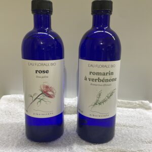 2 bouteilles bleu contenant de l'eau floral de rose et de l'hydrolat de romarin a verbenone